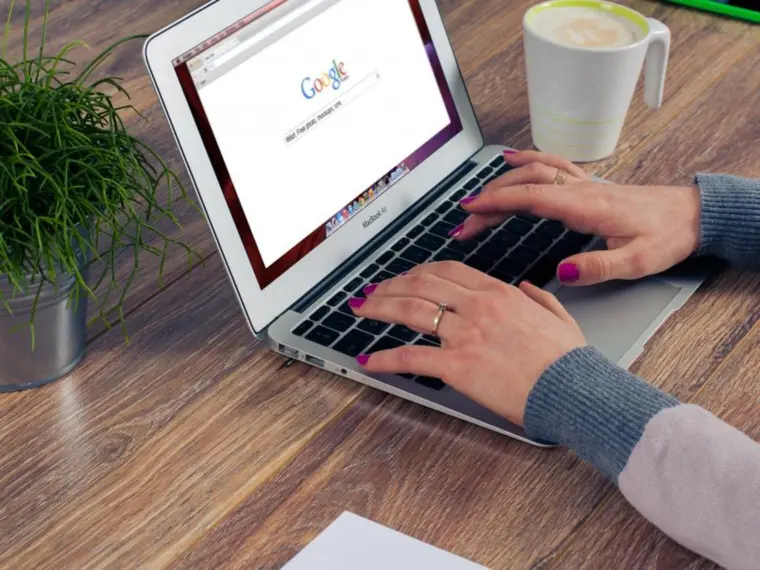 Laptop z otwartą wyszukiwarką Google na drewnianym biurku